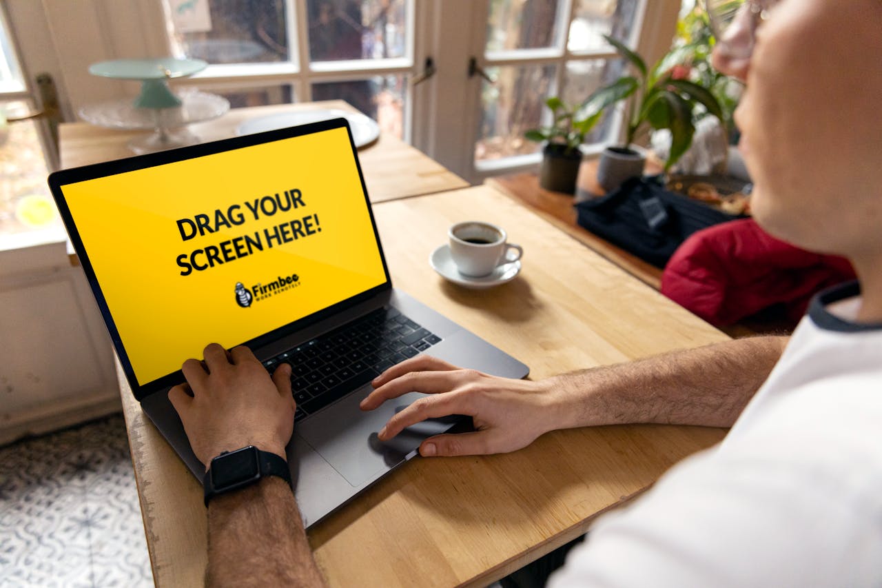 Home Over-the-shoulder view of a person using a laptop indoors with a placeholder screen for customization.